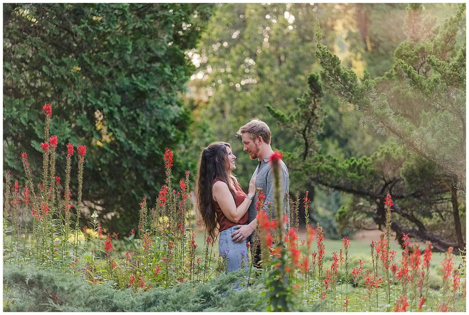 Couple poses for engagement photos in pollinator garden at blandy experimental farm in front royal virginia