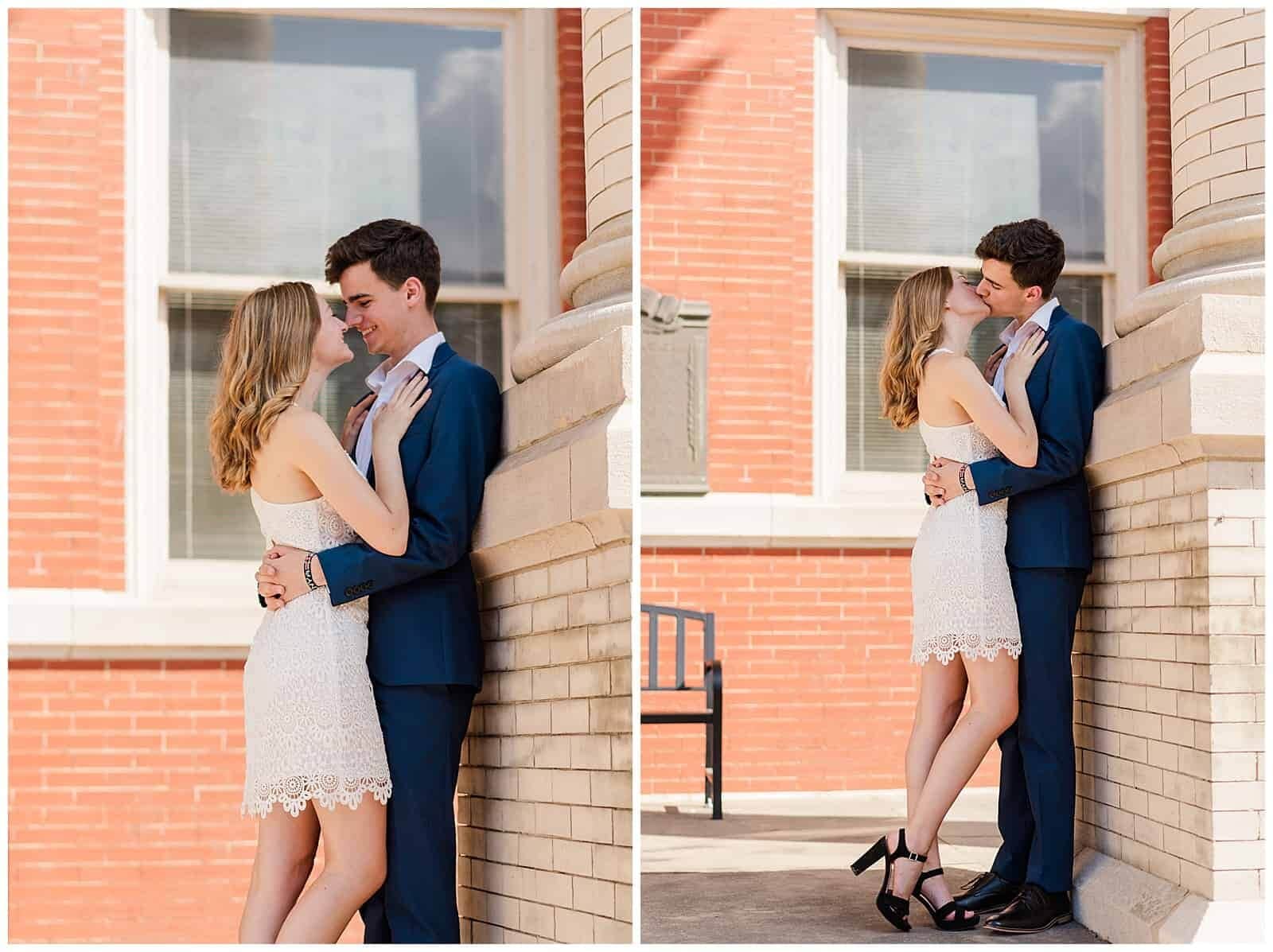 Young couple in blue suit and white sundress smile at each other  posing on augusta county courthouse steps after their spontaneous elopement, posing for elopement photography 