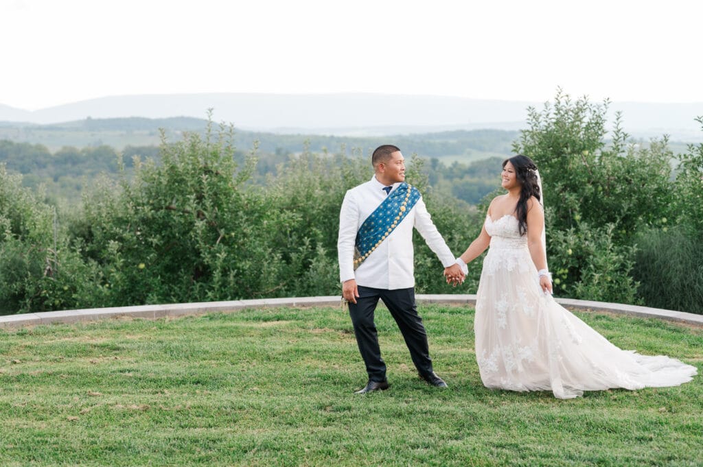 Newlywed couple walks along the mountainside at Showalter's Orchard wedding venue near Harrisonburg