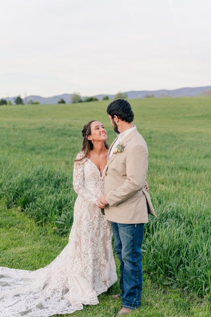 Couple poses for newlywed portraits at Sky Ridge Farm, a barn wedding venue in Waynesboro, VA, near the Blue Ridge Mountains. Photo by Wedding Phootography by Jo Mahaney, a Virginia wedding photographer.