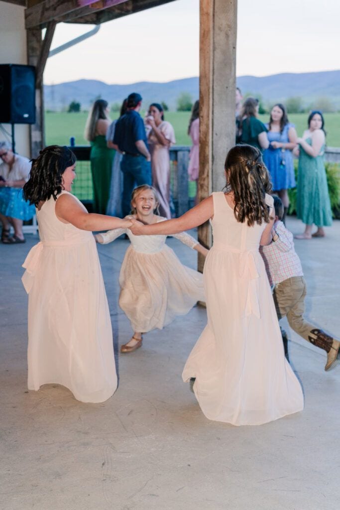 Little girls dancing at a wedding reception at Sky Ridge Farm, a barn wedding venue in Waynesboro, VA, near the Blue Ridge Mountains. Photo by Wedding Phootography by Jo Mahaney, a Virginia wedding photographer.
