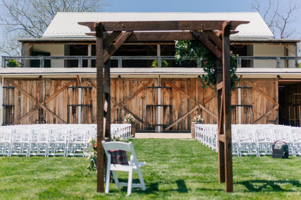Outdoor wedding ceremony location with mountain views at Sky Ridge Farm in Waynesboro, VA, decorated with wooden barrels and ceremony aisle florals. Photo by Wedding Phootography by Jo Mahaney, a Virginia wedding photographer.