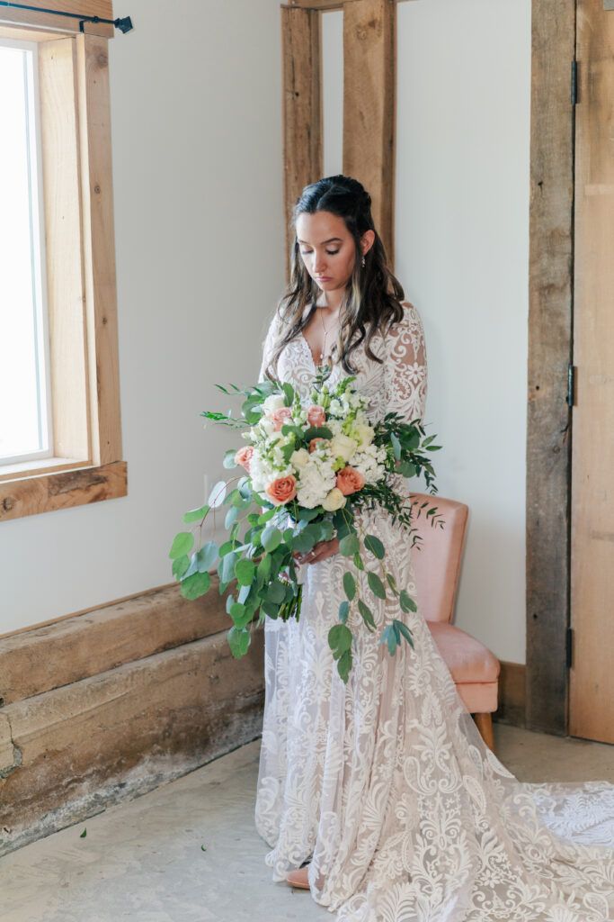 Bride holds large wedding bouquet at Sky Ridge Farm, a barn wedding venue in Waynesboro, VA, near the Blue Ridge Mountains. Photo by Wedding Phootography by Jo Mahaney, a Virginia wedding photographer.