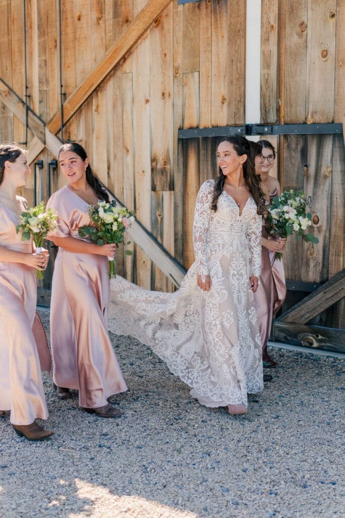 Bridal party walking together before the wedding ceremony behind the barn at Sky Ridge Farm, a barn wedding venue in Waynesboro, VA, near the Blue Ridge Mountains. Photo by Wedding Phootography by Jo Mahaney, a Virginia wedding photographer.
