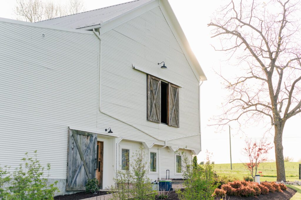 Sunset beside the white barn at Sky Ridge Farm, a barn wedding venue in Waynesboro, VA, near the Blue Ridge Mountains. Photo by Wedding Phootography by Jo Mahaney, a Virginia wedding photographer.