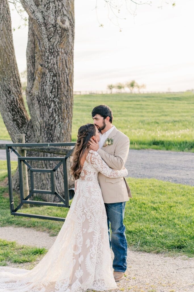 Golden hour couples portraits under the large oak tree at Sky Ridge Farm, a barn wedding venue in Waynesboro, VA, near the Blue Ridge Mountains. Photo by Wedding Phootography by Jo Mahaney, a Virginia wedding photographer.