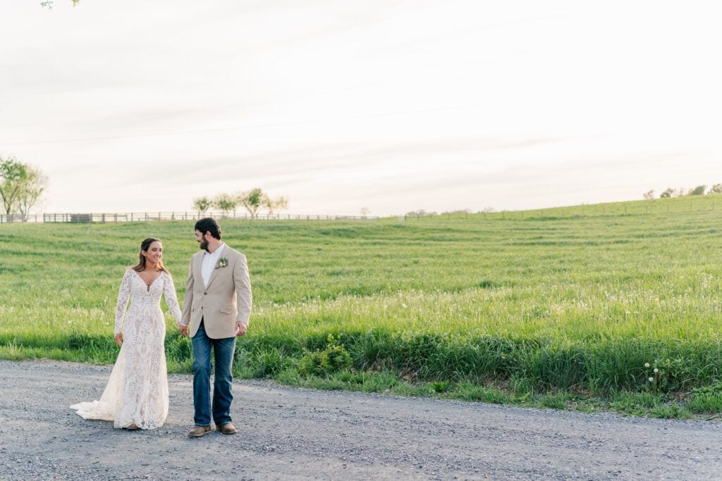 Newlywed portraits in the field across from the venue at Sky Ridge Farm, a barn wedding venue in Waynesboro, VA, near the Blue Ridge Mountains. Photo by Wedding Phootography by Jo Mahaney, a Virginia wedding photographer.