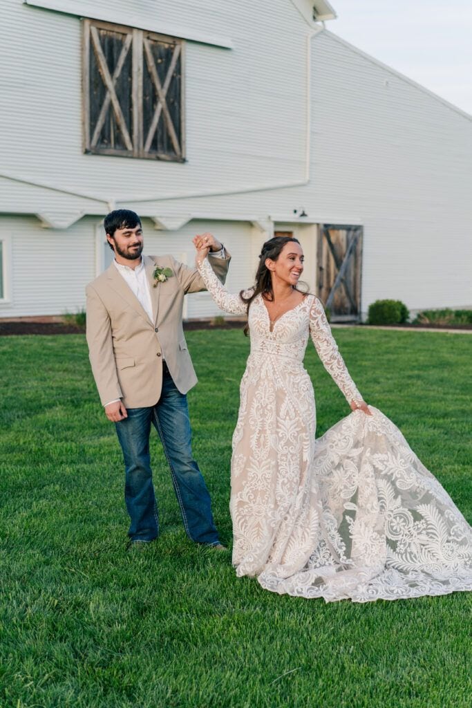 Couple spins and shows off wedding dress at Sky Ridge Farm, a barn wedding venue in Waynesboro, VA, near the Blue Ridge Mountains. Photo by Wedding Phootography by Jo Mahaney, a Virginia wedding photographer.